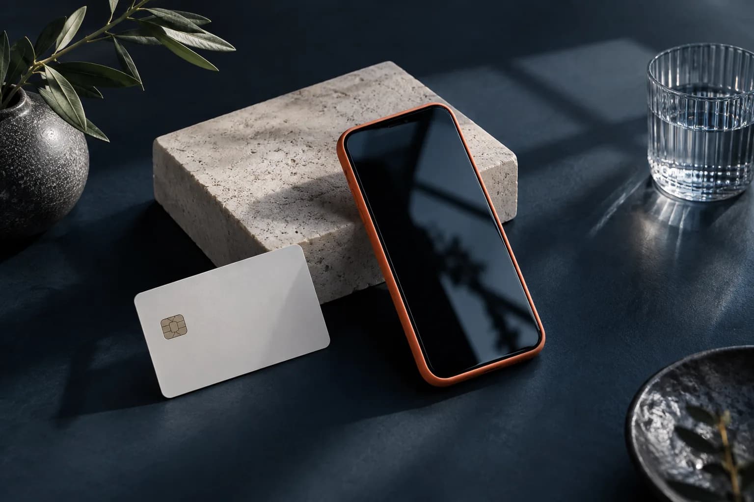 Illustrasjon: mobiltelefon med oransje deksel og et bankkort.